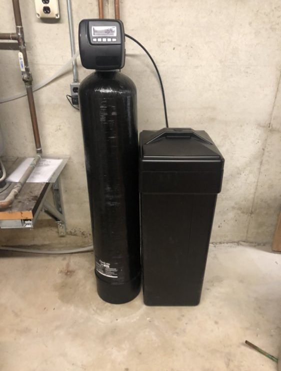 Single softener tank and brine tank on a basement floor
