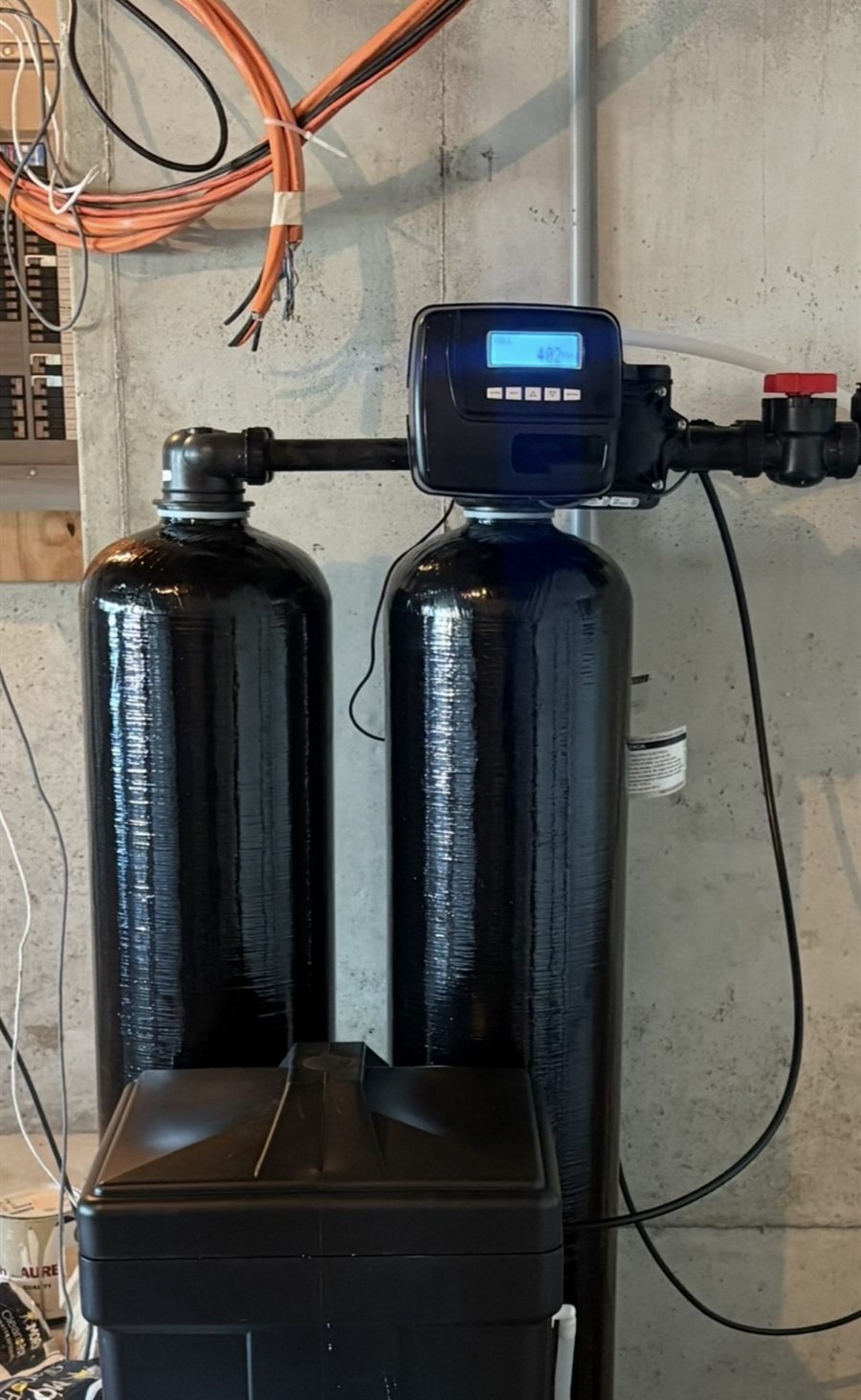 Twin-tank water softener: two tanks sharing one lit digital valve, with a brine tank in front